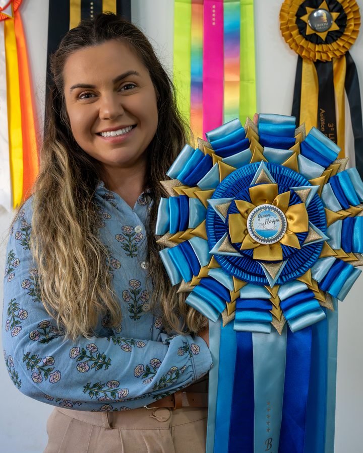 Daia Soares segurando a roseta de Best in Show do Groom Floripa